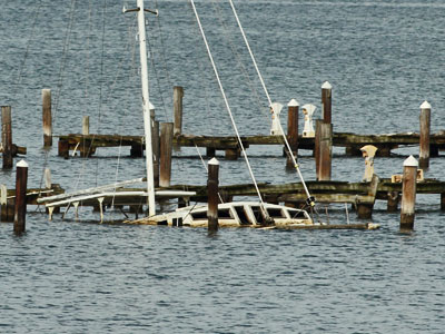 storm damaged dock and sunken sailboat